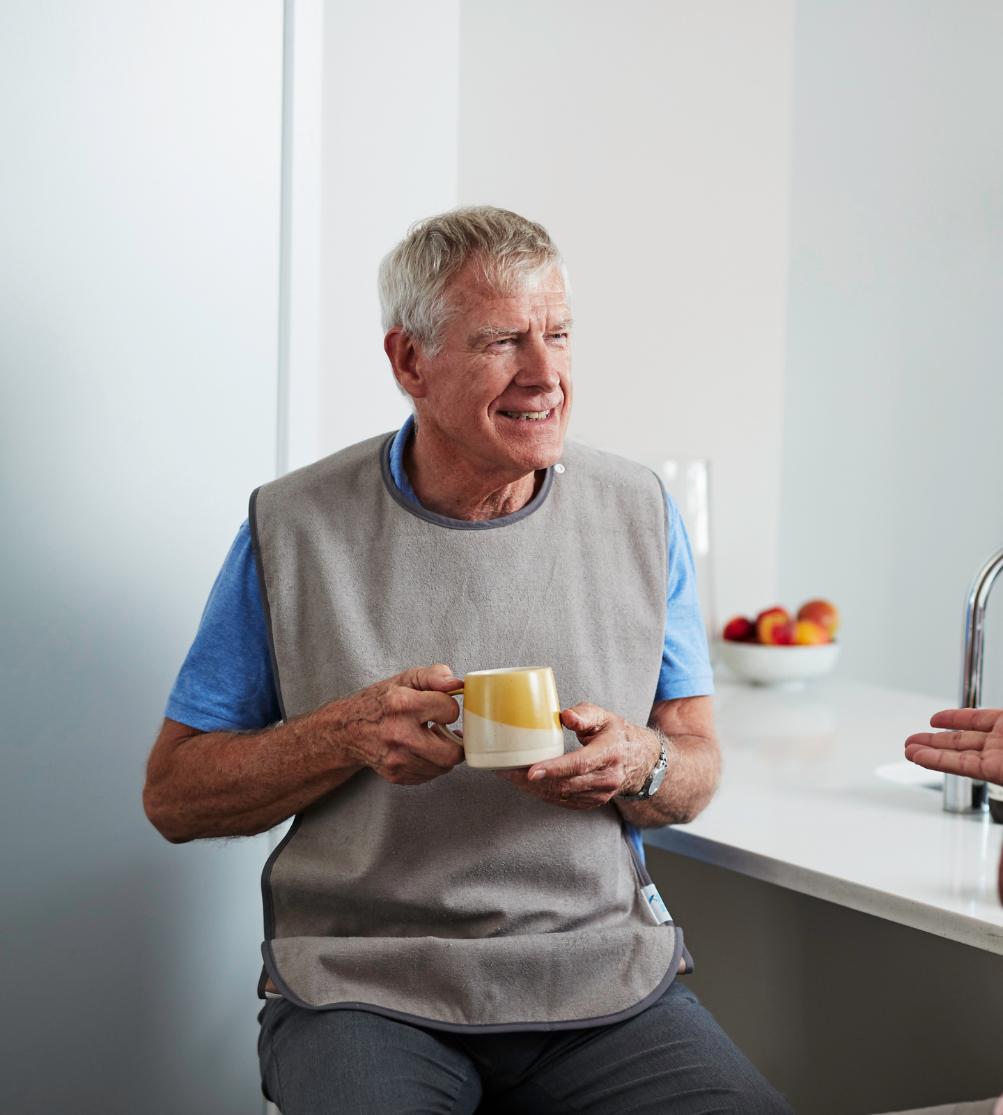 Adult man with grey, waterproof tray bib.